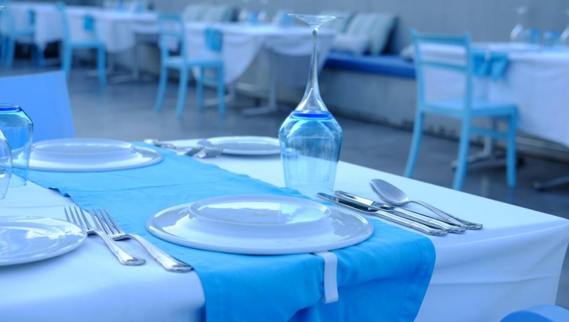 A table set with plates and silverware and a bottle of water
