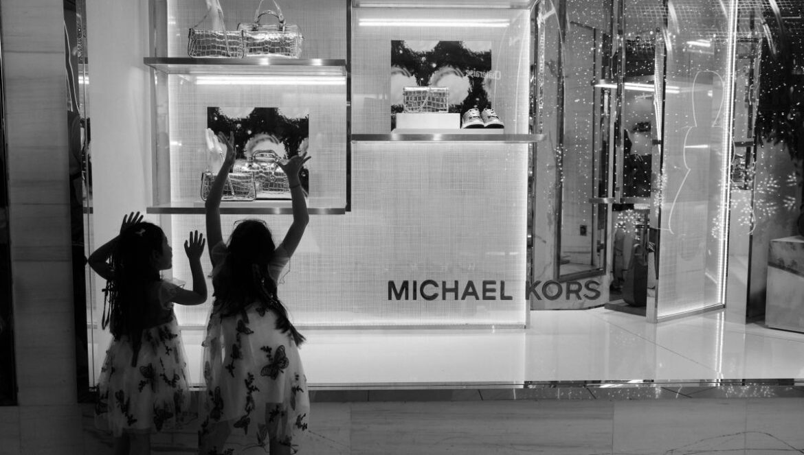 Two women standing in front of a store window