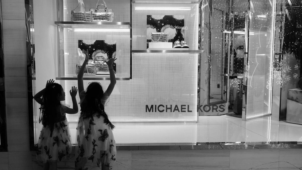 Two women standing in front of a store window