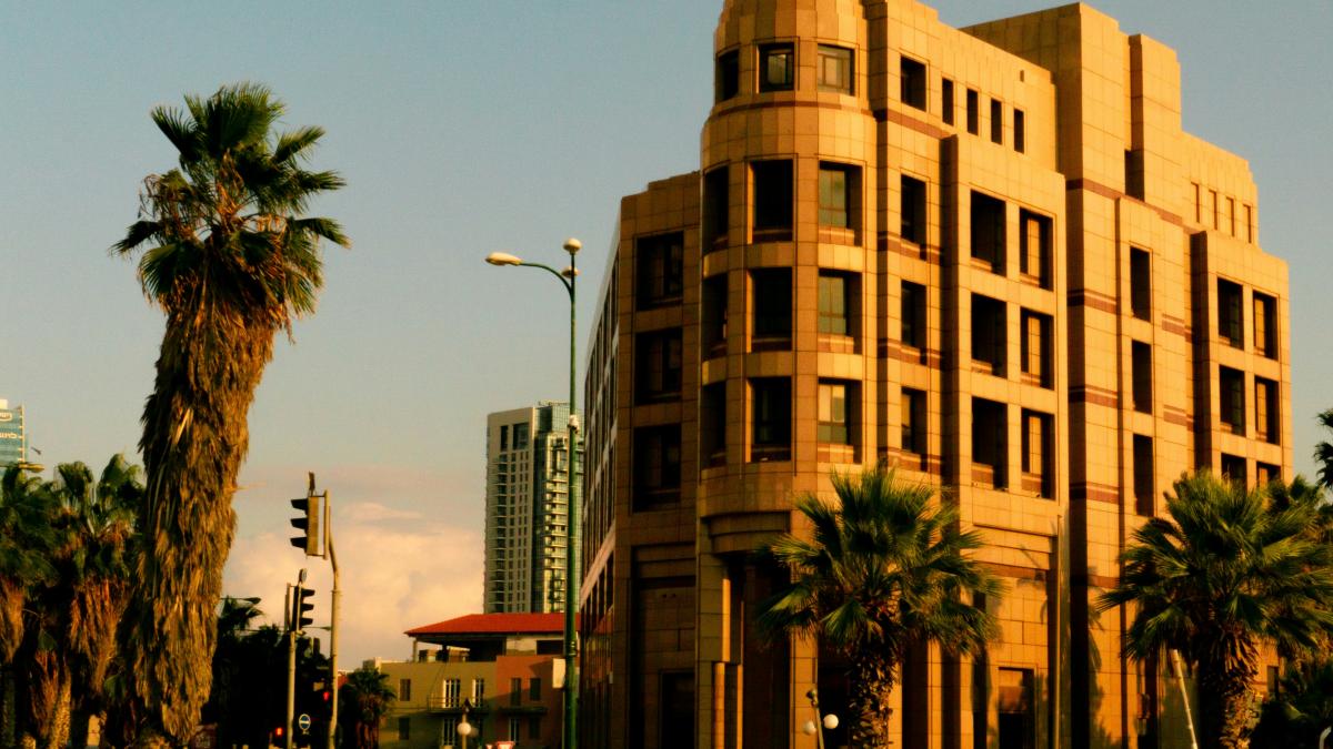 cars parked in front of brown concrete building during daytime