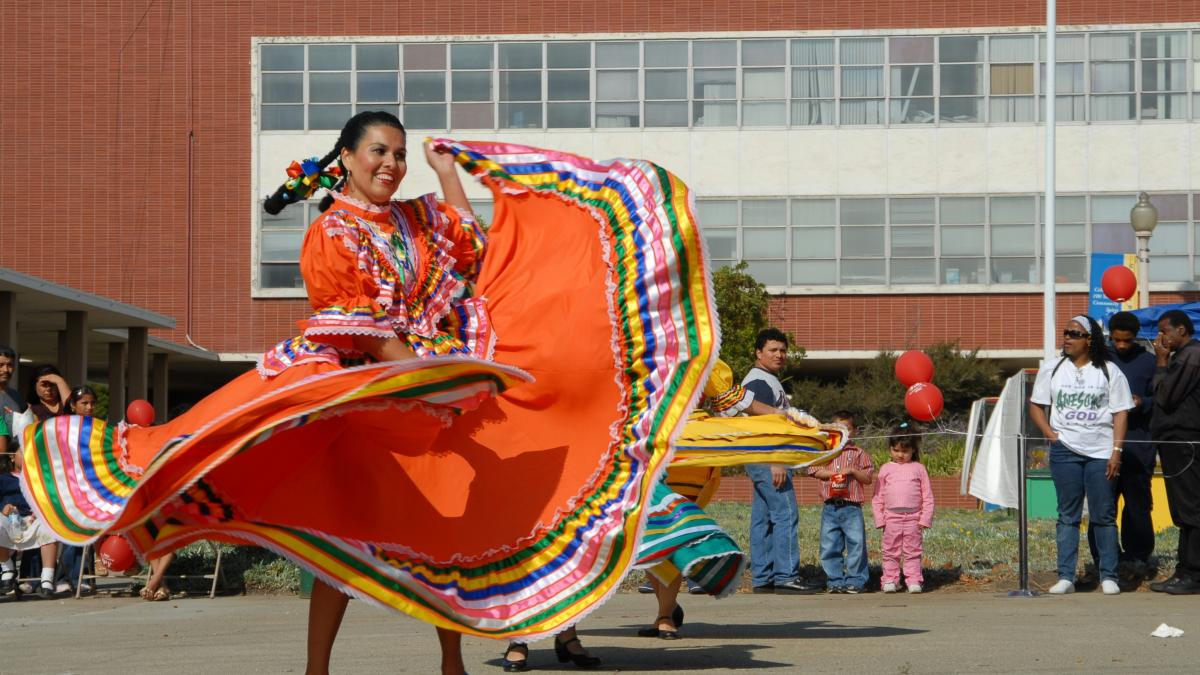 woman in red yellow and blue dress holding red and yellow textile