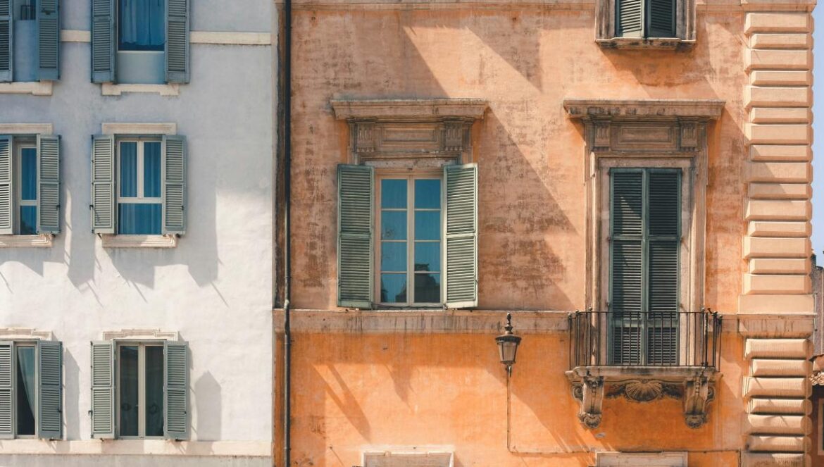 brown building beside white building
