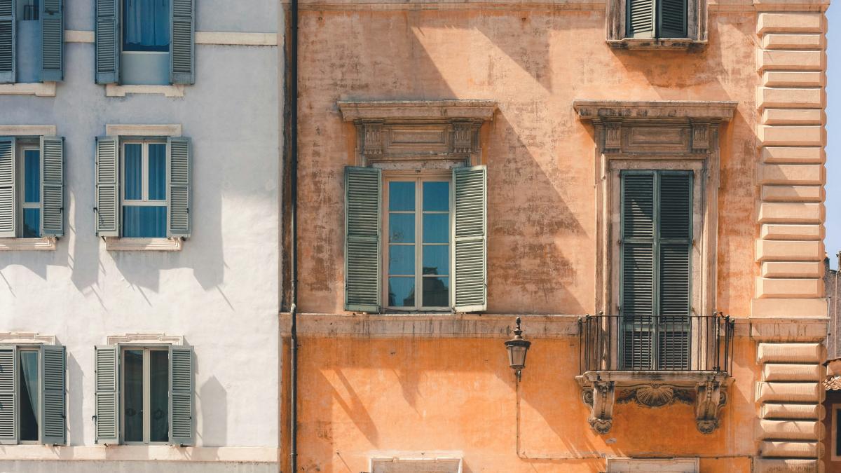 brown building beside white building