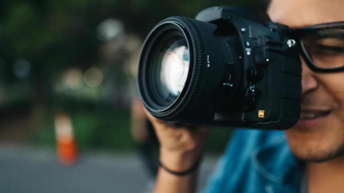 man holding black DSLR camera
