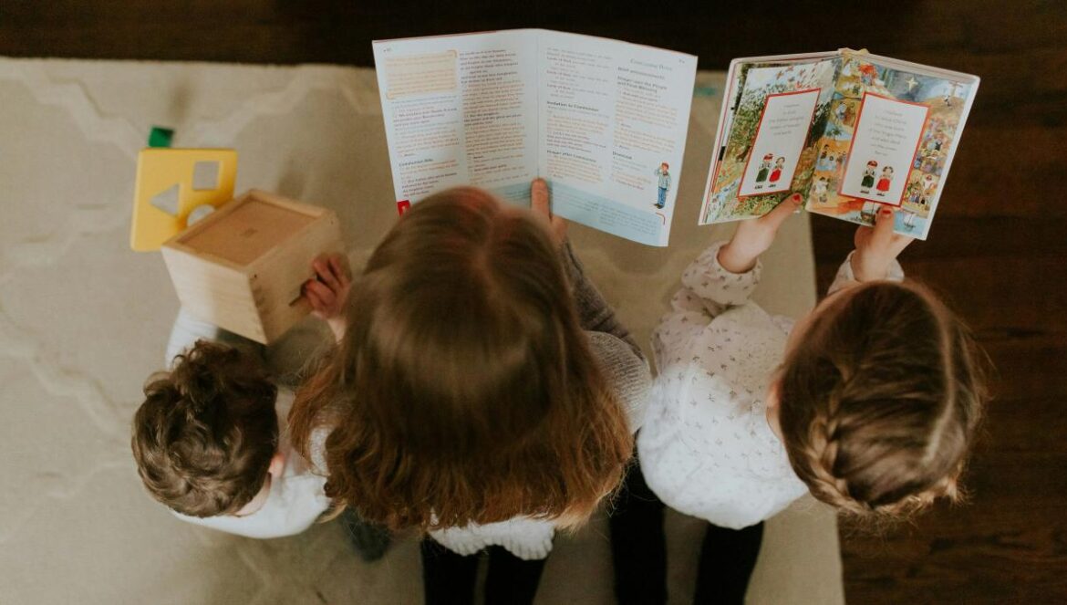 girl in white long sleeve shirt reading book