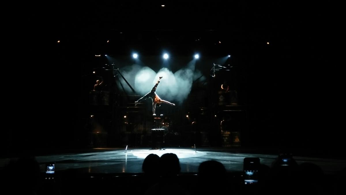 man performing acrobats on stage