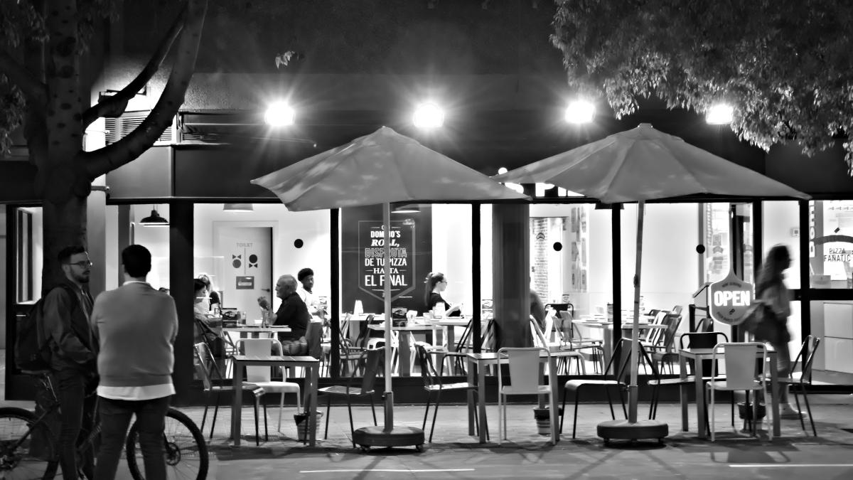 a group of individuals stand outside a restaurant