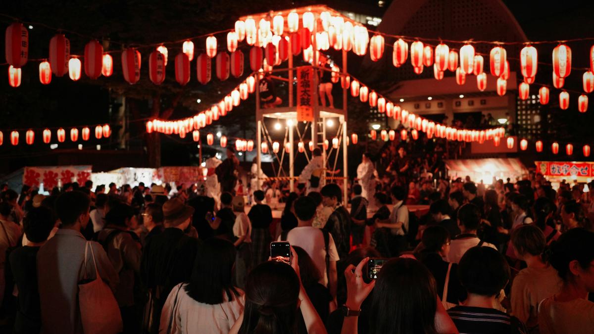 a crowd of people standing around a building at night