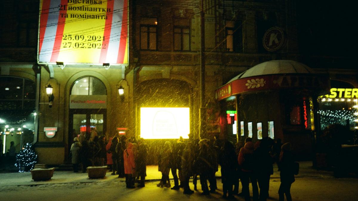 a group of people walking in a street at night