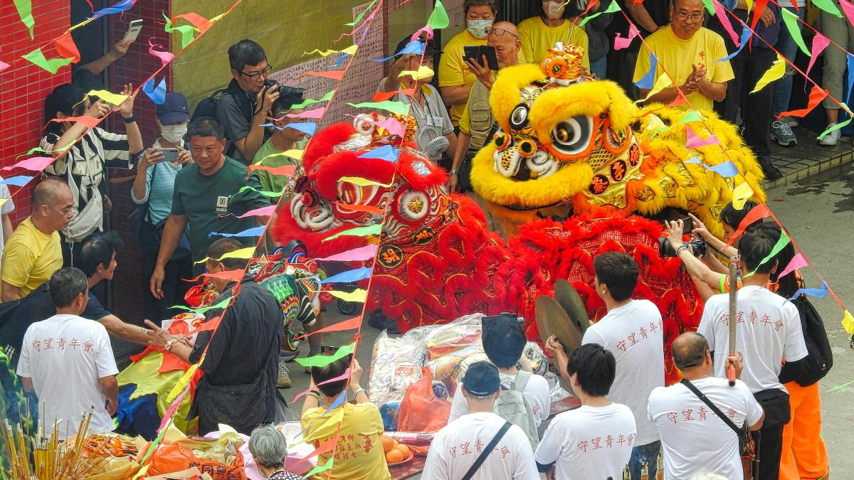 a group of people standing around a dragon float