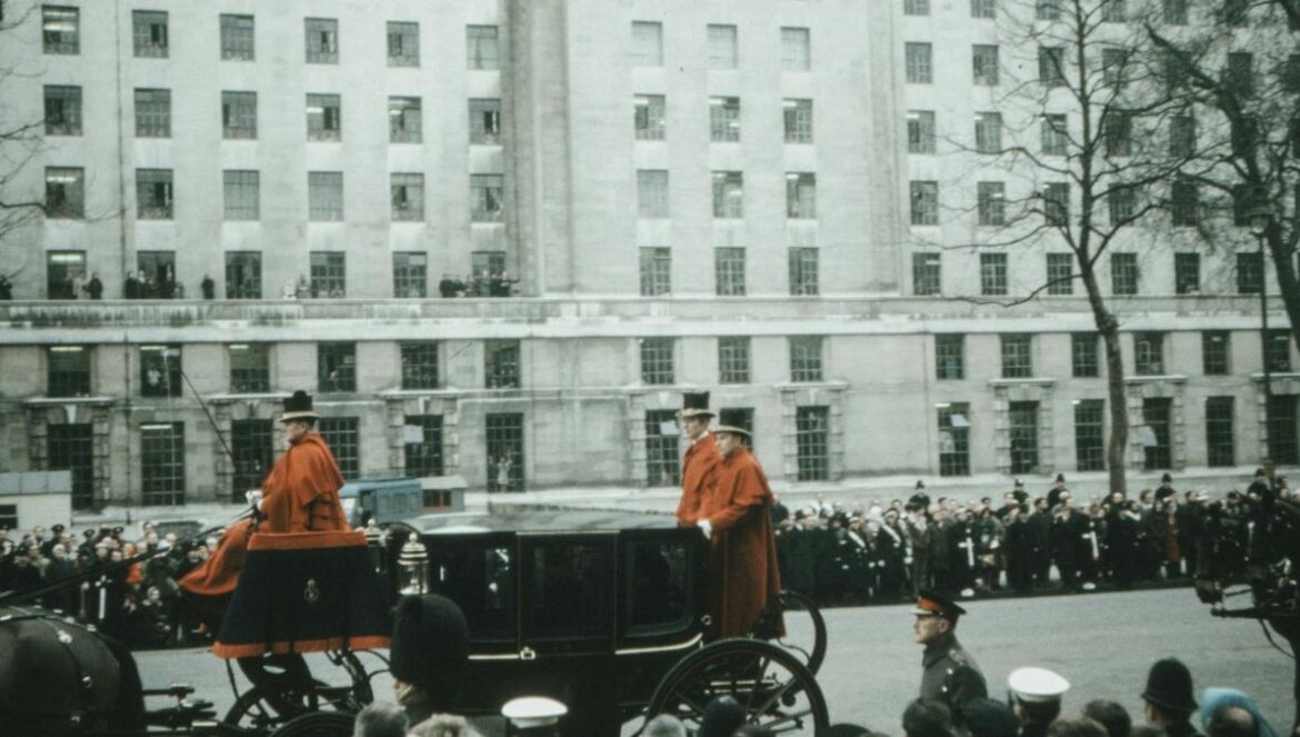 man in orange shirt standing on the street