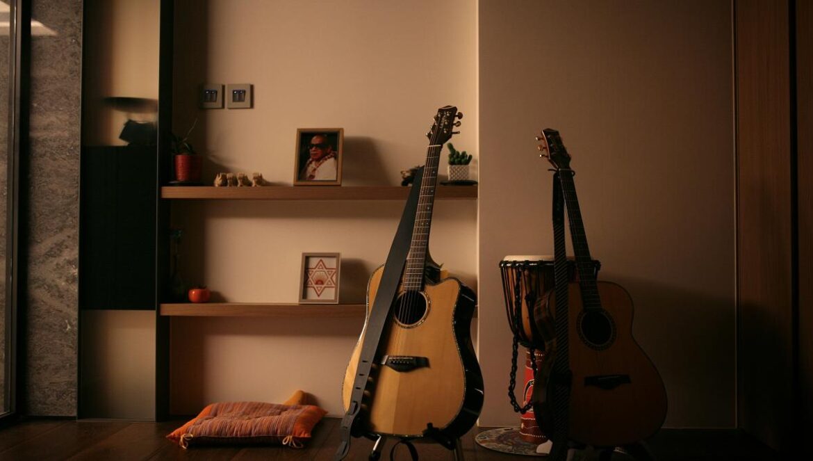 brown and black acoustic guitars on black steel stand