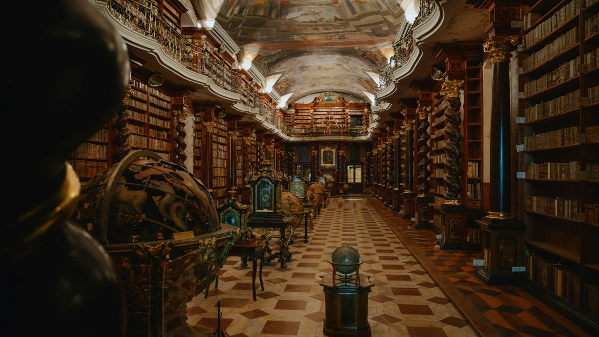 a long room with many bookshelves and a clock