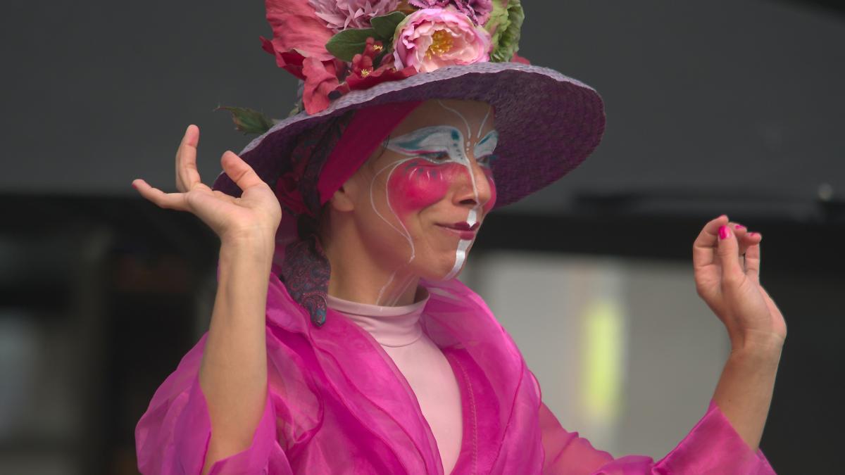 A woman in a pink dress and a purple hat