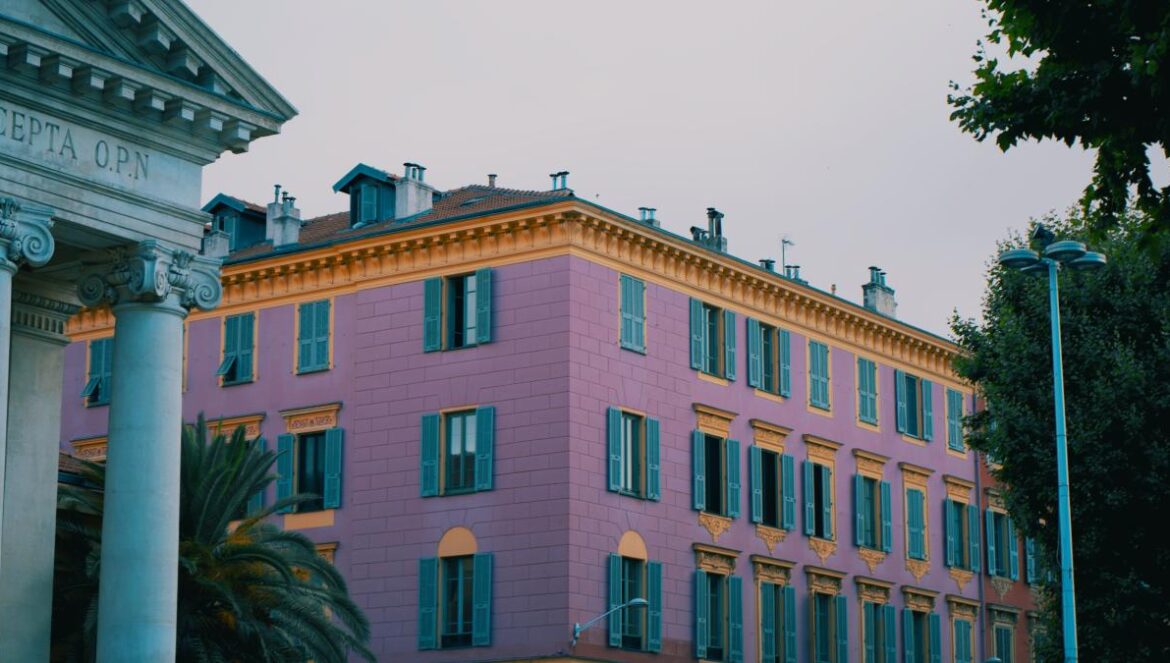 A large pink building sitting next to a tall white building