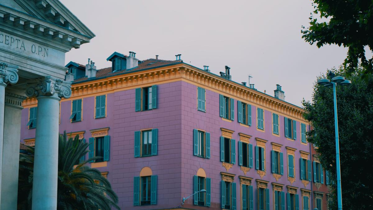 A large pink building sitting next to a tall white building