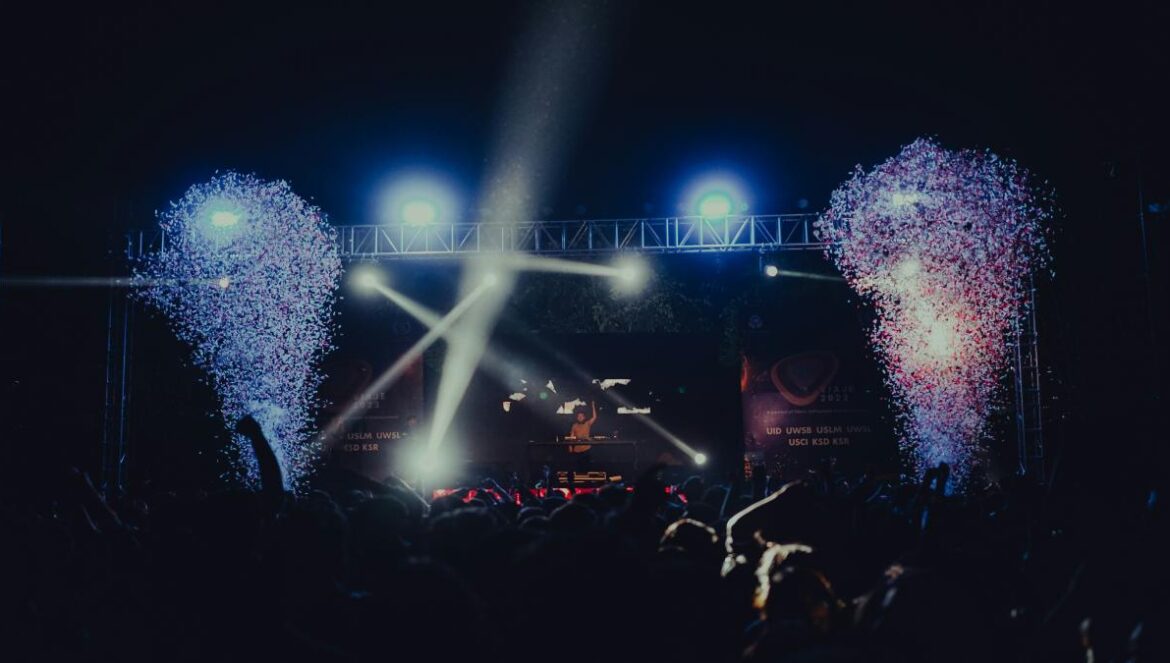 a crowd of people at a concert with fireworks