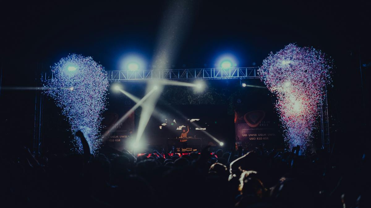 a crowd of people at a concert with fireworks