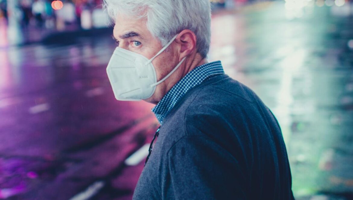 a man wearing a face mask on a city street