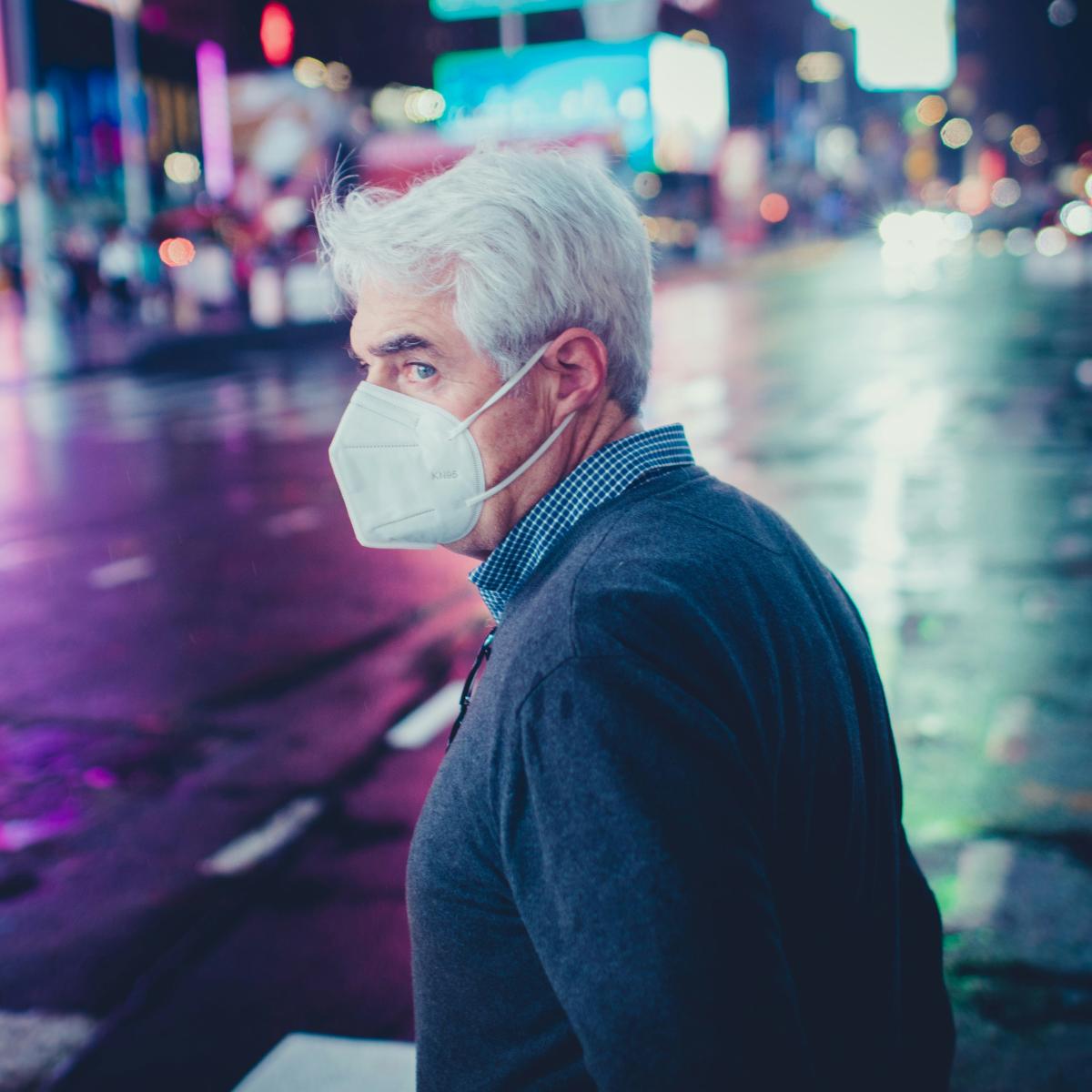 a man wearing a face mask on a city street