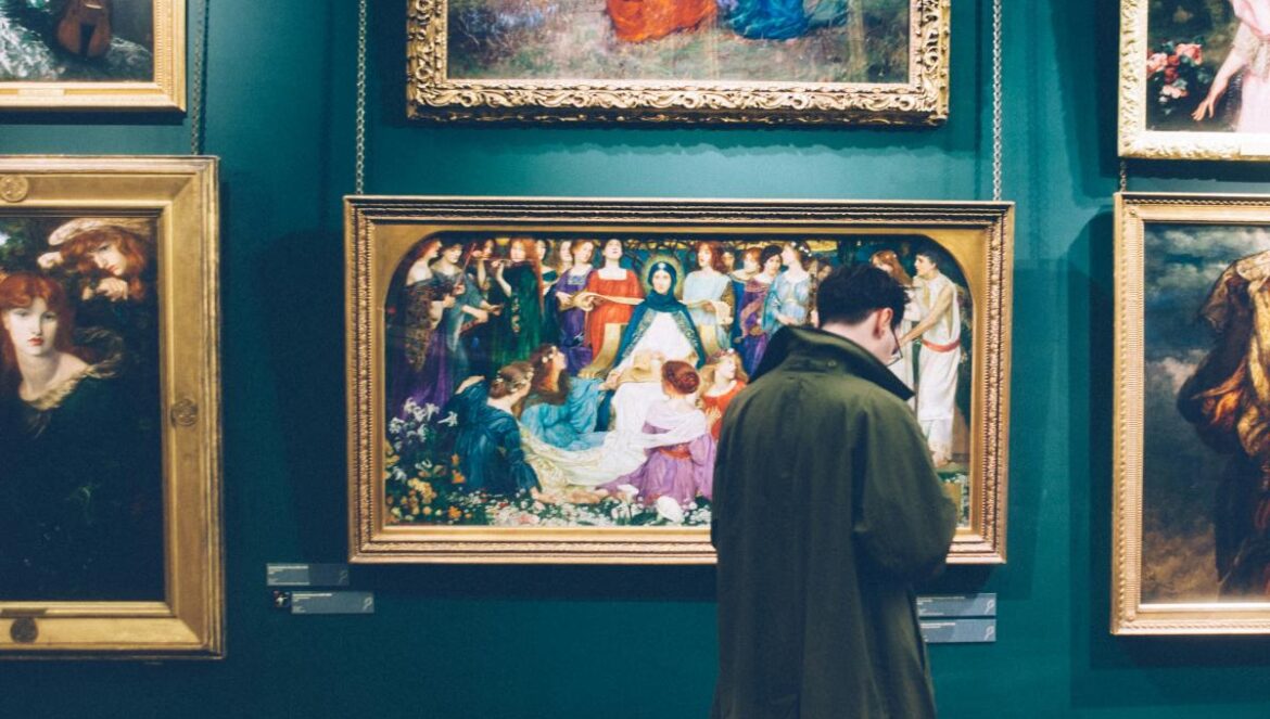 person standing near six paintings inside gallery