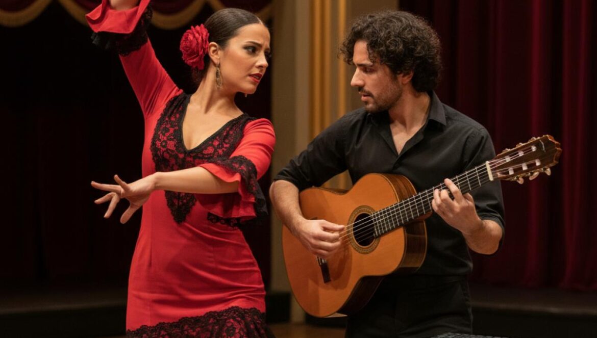 Danseuse flamenca et musicien avec guitare et sampler sur scène, lumière chaude du théâtre.